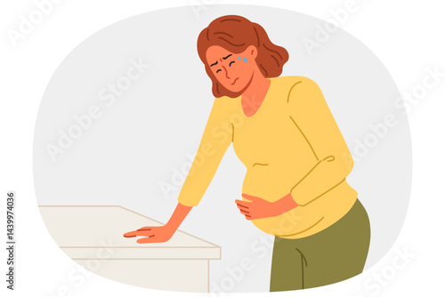 Pregnant woman holds stomach, standing near cabinet, experiencing pain due to complications caused by fetal development disorders. Pregnant girl needs hospitalization to avoid miscarriage