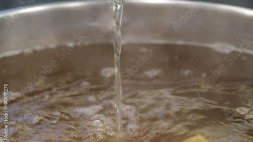 Ladle pouring broth into a pot