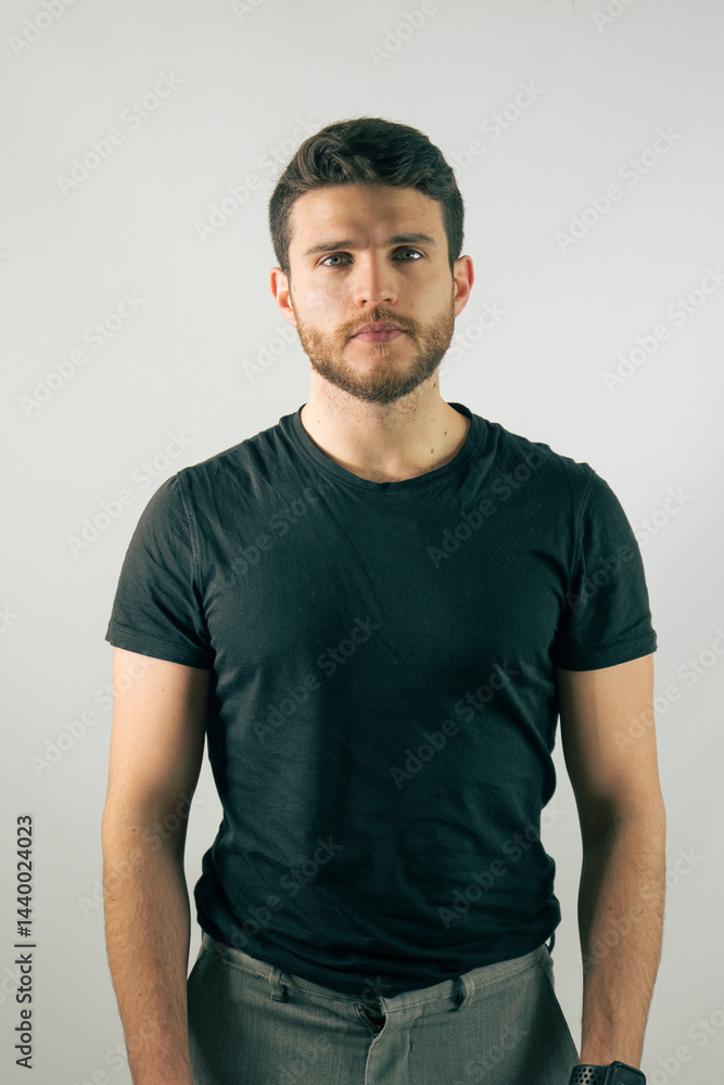 Fototapeta premium Young man standing confidently against a plain backdrop