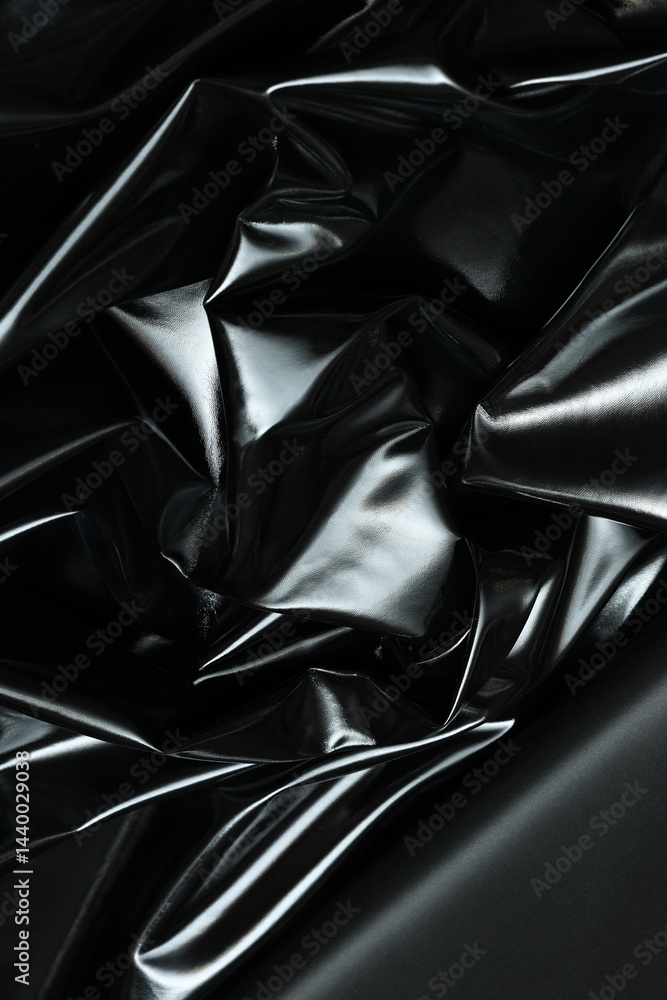 Fototapeta premium Sleek and glossy black patent artificial leather with a reflective surface. Its smooth, polished texture showcases modern elegance, ideal for fashion, upholstery, and high-end accessories.