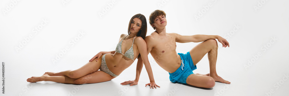 Obraz premium Confident young woman and man, stylish couple relaxing in stylish beachwear, posing against white studio background. Concept of summer, fashion, youth culture, vacation. Banner