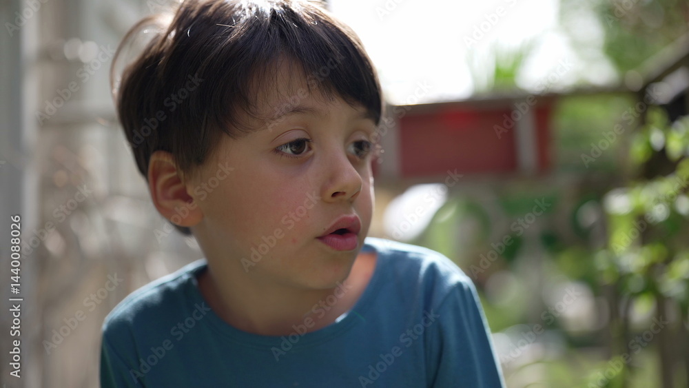 Young boy looking intently to the side, with a thoughtful expression on a sunny day. the quiet moment of a child lost in thought, surrounded by the greenery of the outdoors-SD 480p Young boy looking intently to the side, with a thoughtful expression on a sunny day. the quiet moment of a child lost in thought, surrounded by the greenery of the outdoors-SD 480p