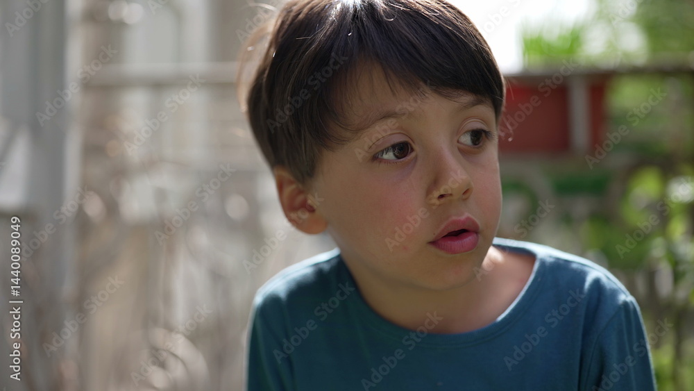 Young boy looking intently to the side, with a thoughtful expression on a sunny day. the quiet moment of a child lost in thought, surrounded by the greenery of the outdoors-SD 480p Young boy looking intently to the side, with a thoughtful expression on a sunny day. the quiet moment of a child lost in thought, surrounded by the greenery of the outdoors-SD 480p