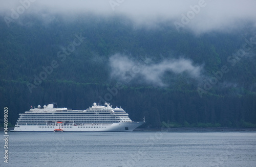 Obraz na płótnie Luxury cruiseship cruise ship liner Orion and kayaks boat in Hoonah Icy Strait Point Bay, Alaska with low hanging clouds and nature landscape scenery w salonie