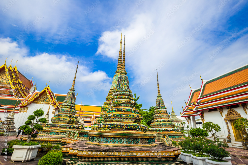 Fototapeta premium Beautiful pagoda of Wat Pho temple complex against blue sky sightseeing travel in Bangkok