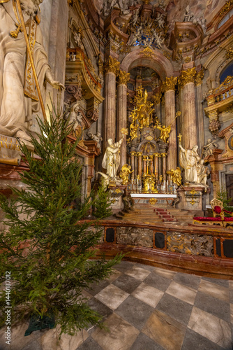 Obraz na płótnie Christmas tree standing in richly decorated baroque church interior in Prague w salonie