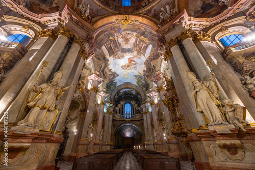 Interior of St. Nicholas Church showing baroque architecture and frescoes in Prague