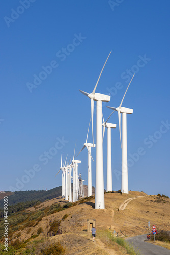 Obraz na płótnie Wind turbines generating clean energy on a hilltop under a clear blue sky w salonie
