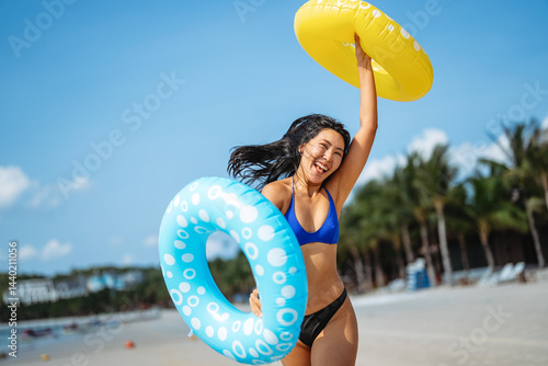 Obraz na płótnie Excited young woman enjoying her tropical beach vacation and celebrating a fun-filled summer getaway w salonie