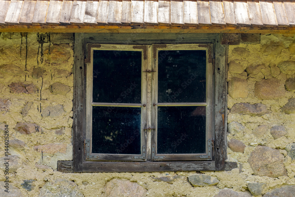 Window in the wall of a stone house in the village