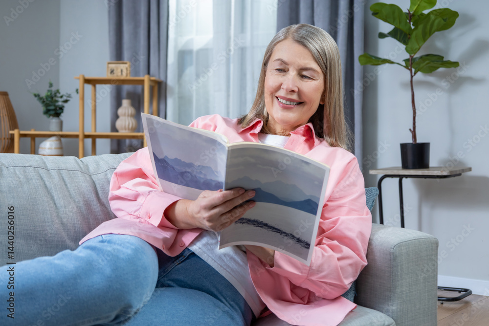 Mid aged woman reading a newspaper at home and looking involved Mid aged woman reading a newspaper at home and looking involved