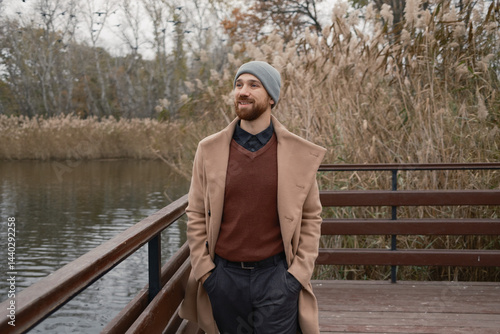 Obraz na płótnie Bearded man in casual winter clothes outdoors near water surrounded by nature w salonie