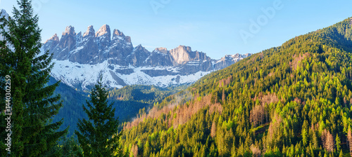 Majestic mountain landscape with snow capped peaks and forest scene near Valley of Funes at Dolomites, Italy.