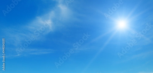 Blue sky with white clouds and bright sun.
