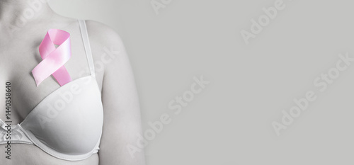 Obraz na płótnie Woman in bra with pink ribbon on light background, closeup. w salonie