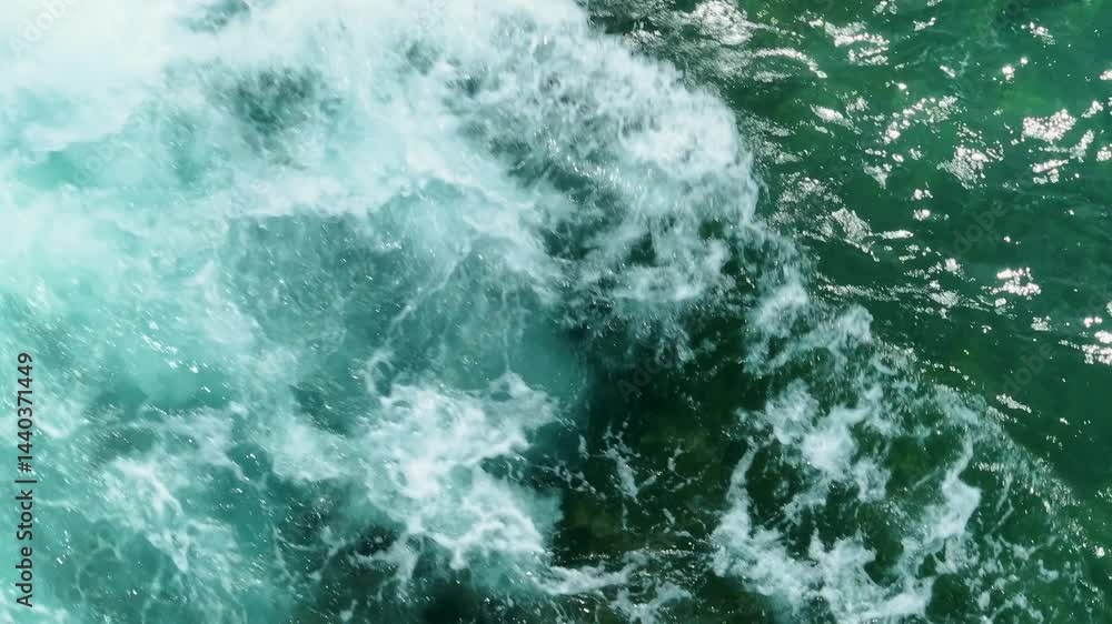 A slow-motion aerial view captures the moment a wave crashes, sending a burst of water upwards, highlighting the dramatic force of the ocean as it meets the rocks.
A slow-motion aerial view captures the moment a wave crashes, sending a burst of water upwards, highlighting the dramatic force of the ocean as it meets the rocks.
