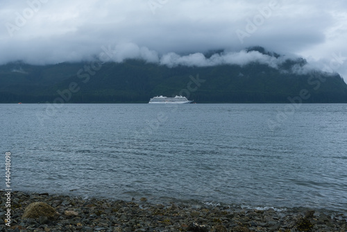 Obraz na płótnie Luxury cruiseship cruise ship liner Orion and kayaks boat in Hoonah Icy Strait Point Bay, Alaska with low hanging clouds and nature landscape scenery w salonie