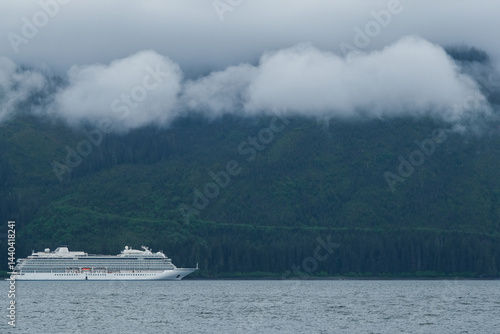Obraz na płótnie Luxury cruiseship cruise ship liner Orion and kayaks boat in Hoonah Icy Strait Point Bay, Alaska with low hanging clouds and nature landscape scenery w salonie