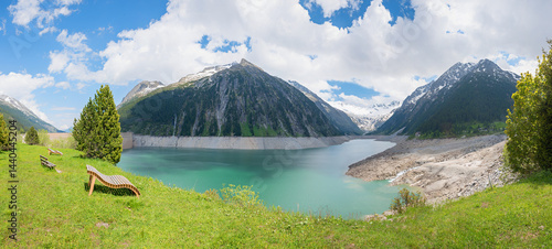 Obraz na płótnie green meadow with sunbeds at lakeside Schlegeisspeicher, dam lake Zillertal alps in spring. w salonie