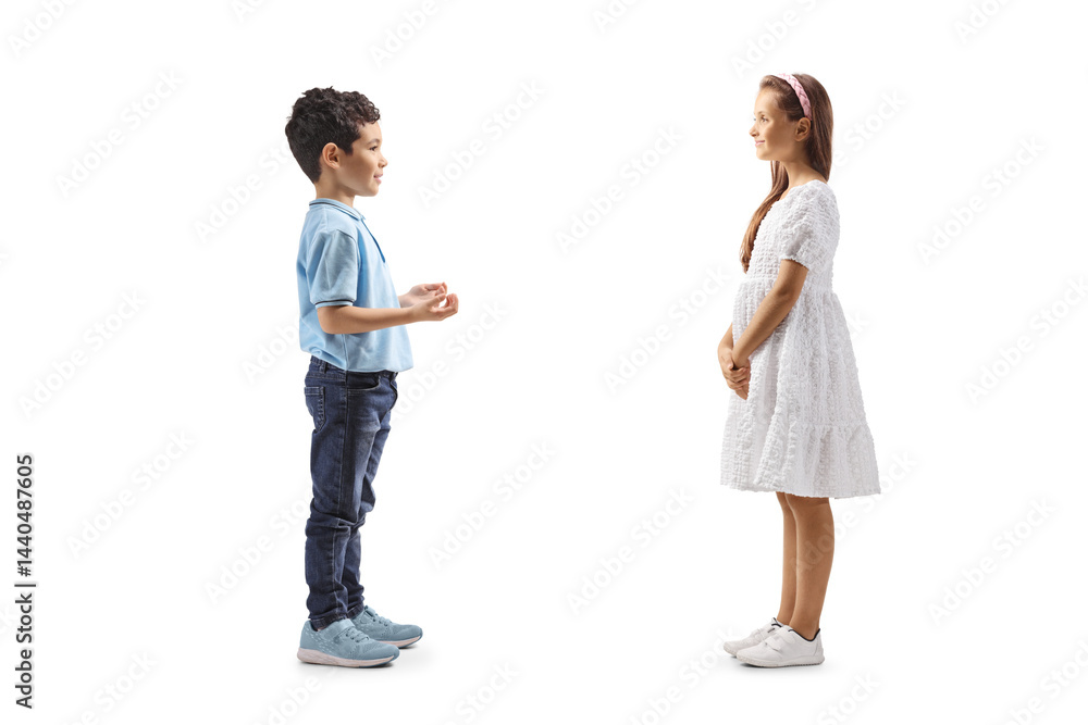 Full length profile shot of a boy having a conversation with a girl in a white dress Full length profile shot of a boy having a conversation with a girl in a white dress