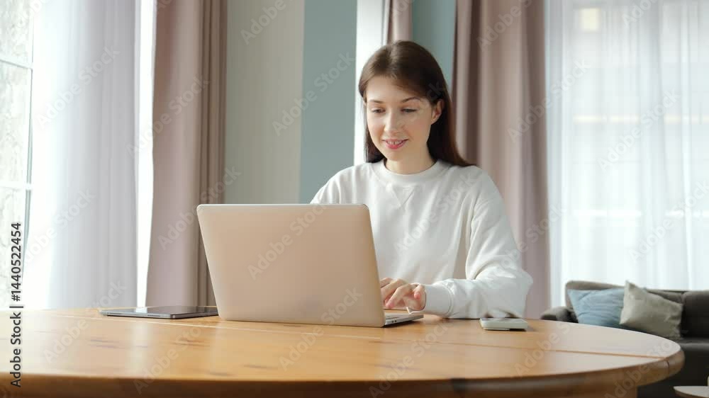 Soft sunlight illuminates a cheerful woman working on her laptop in a serene setting. Soft sunlight illuminates a cheerful woman working on her laptop in a serene setting.