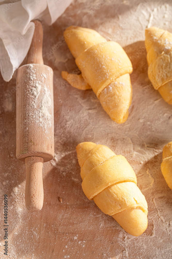 Homemade french croissants preparing from raw dough.