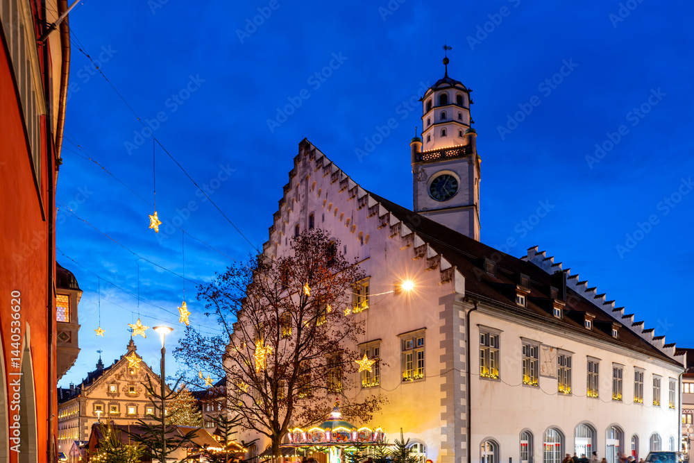 Romantic Christmas market in Ravensburg with historic town hall illuminated under a deep blue evening sky