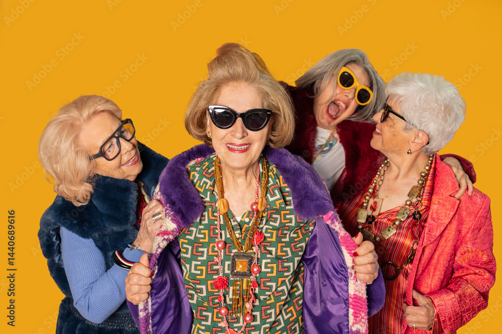 Obraz premium Four stylish senior women showing fashion and happiness on yellow background