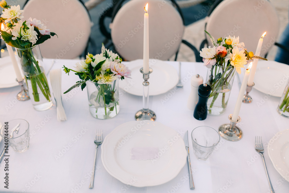 Fototapeta premium Elegant Dinner Table Setting with Candles and Flowers