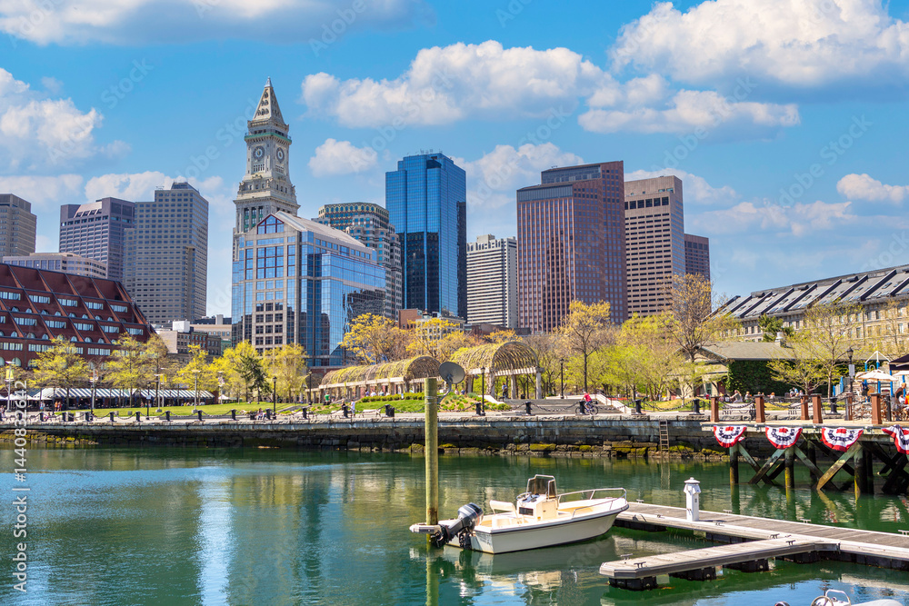 A vibrant daytime view of Boston’s downtown skyline featuring modern skyscrapers, historic architecture, and a calm waterfront with marina.
