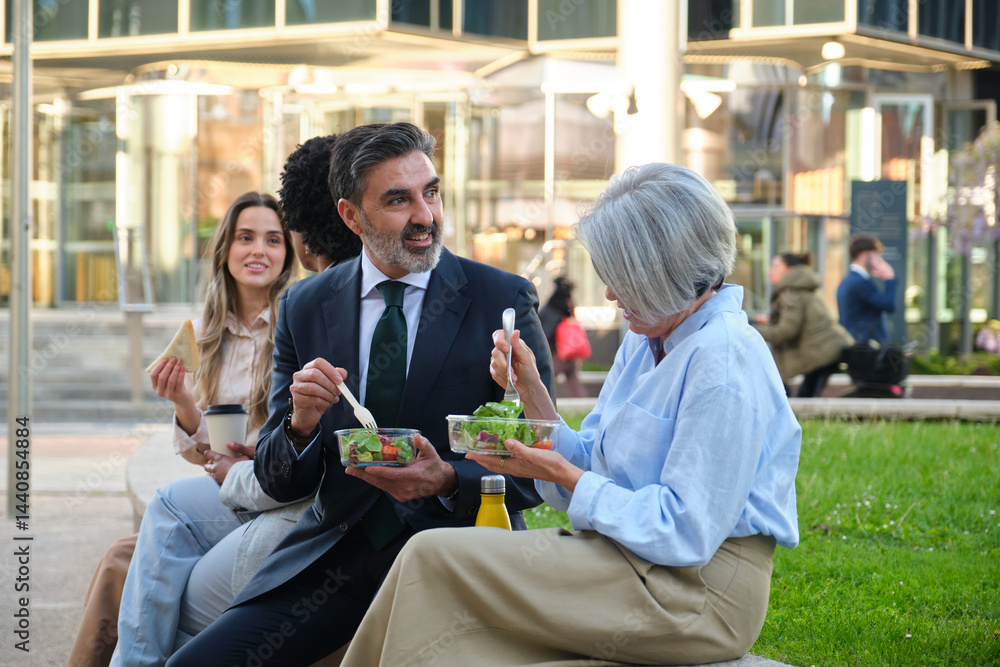 Multi ethnic business team enjoying a healthy lunch break together outdoors