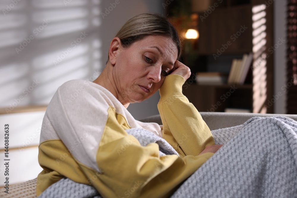 Fototapeta premium Depressed woman on sofa at home in evening