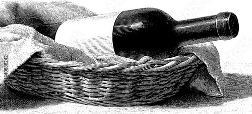 Vintage wine bottle in woven basket with cloth.