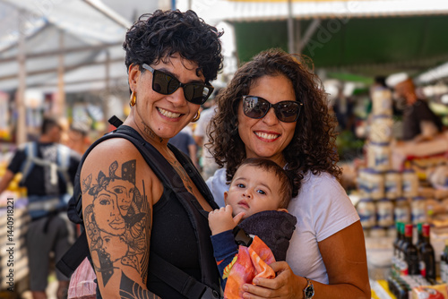 Foto Portrait of Brazilian lesbian couple and baby at a street market in São Paulo