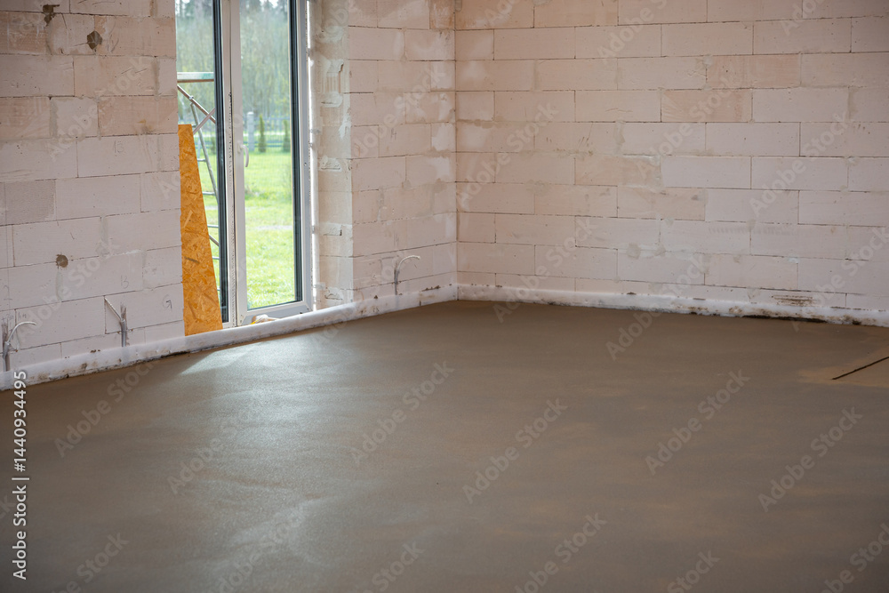 Interior under construction with white brick walls, Estrich concrete flooring, glass door, visible wiring, and underfloor heating installation progress.