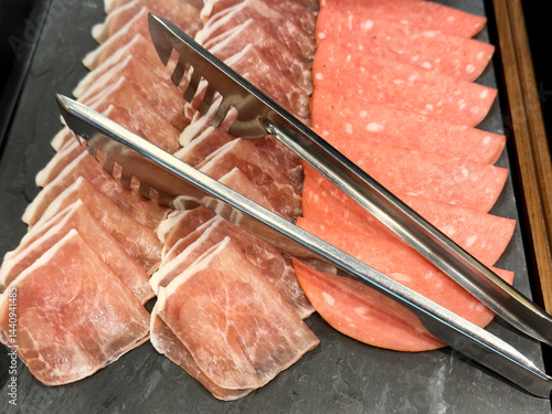 Close up of raw sliced beef and pork on a platter