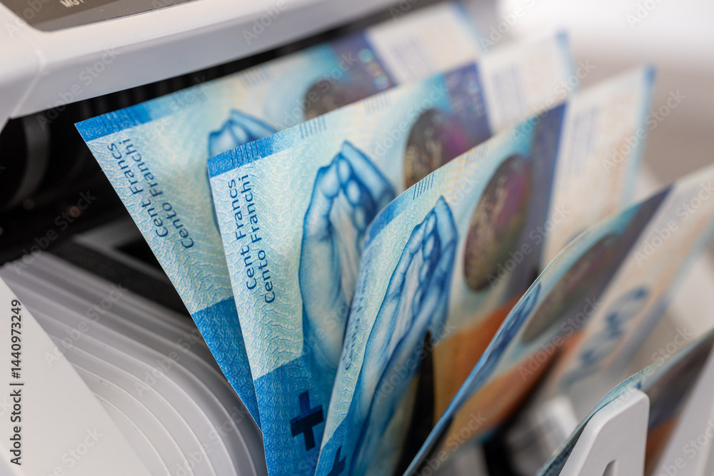 Swiss Francs in a money counter. Financial and business concept. 100 franc notes, banking, economics, investments in Switzerland. close up