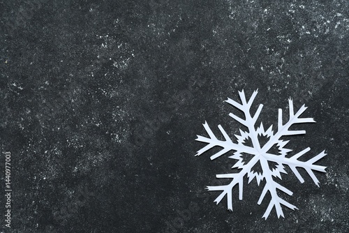 One beautiful paper snowflake on dark grey table, top view. Space for text