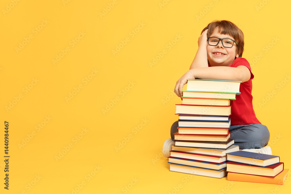 Boy with many different books on orange background. Space for text Boy with many different books on orange background. Space for text