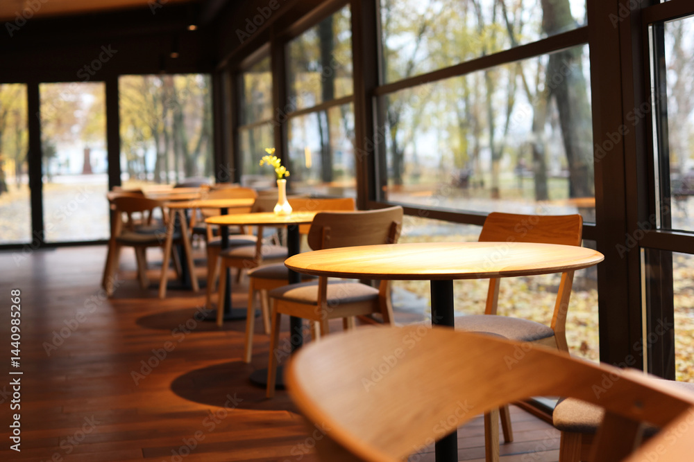 Fototapeta premium Stylish cafe with large windows and comfortable furniture. Interior design