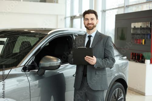 Wallpaper Mural Happy salesman with clipboard near new car in salon Torontodigital.ca