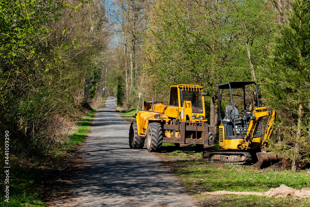 Heavy machinery working on a rural road in springtime Heavy machinery working on a rural road in springtime