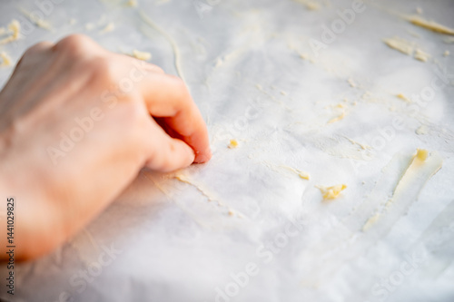 Obraz na płótnie Preparing parchment for baking pizza, greasing parchment with butter w salonie
