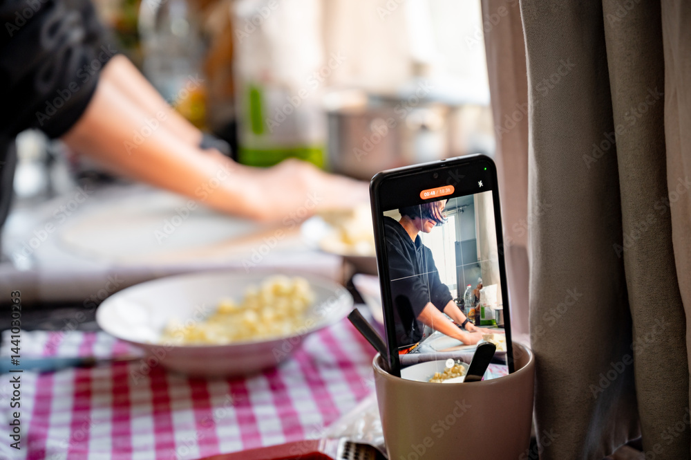 Filming on a phone as a girl cooks pizza. Home shooting. Video content for social networks.