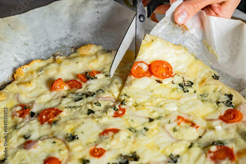 Obraz na płótnie Cutting fresh homemade pizza with scissors w salonie