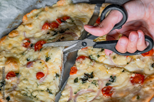 Obraz na płótnie Cutting fresh homemade pizza with scissors w salonie