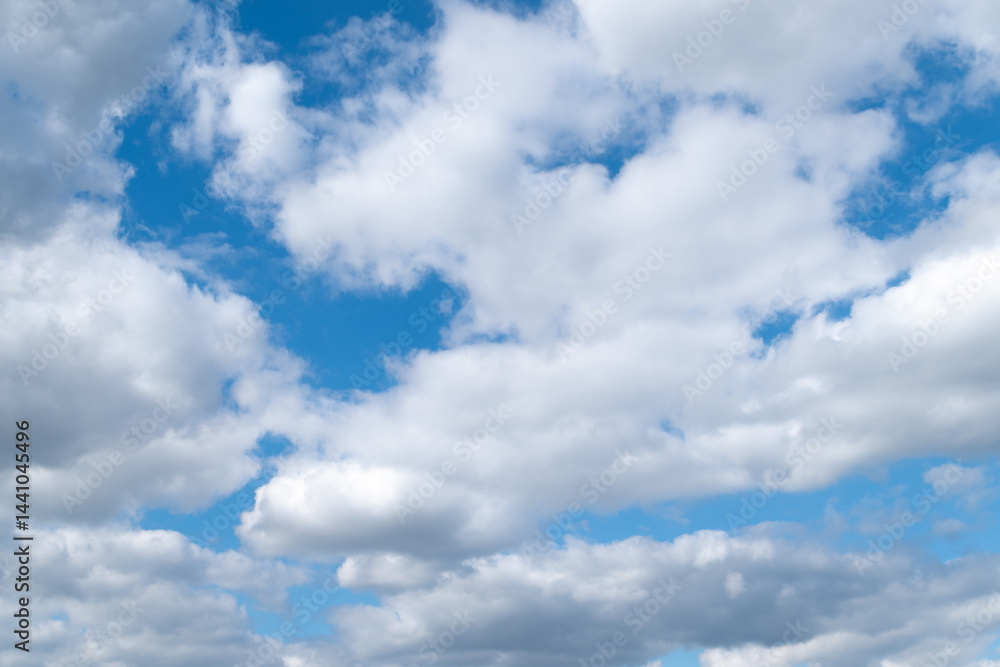 Naklejka premium White clouds in the blue sky on a bright sunny day.