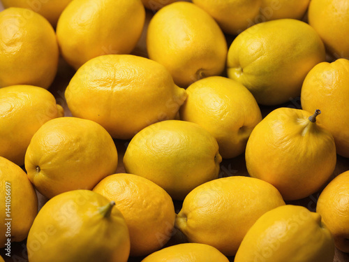 The image is a close-up photograph of a pile of lemons, all neatly arranged next to each other. 