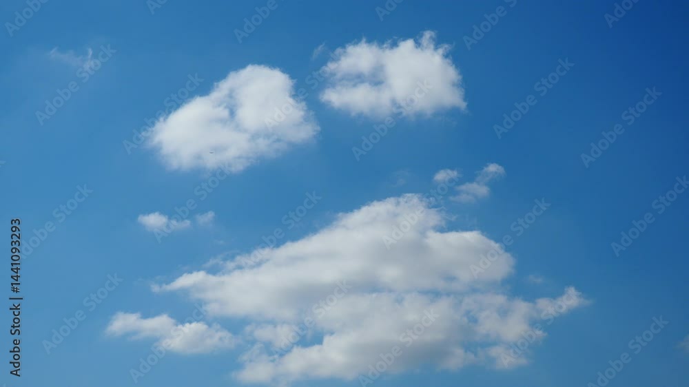 Fluffy white clouds drift serenely in a brilliant azure expanse as sunlight bathes the world below. Picturesque moment of tranquility. Soft little white clouds float gracefully across clear blue sky. Fluffy white clouds drift serenely in a brilliant azure expanse as sunlight bathes the world below. Picturesque moment of tranquility. Soft little white clouds float gracefully across clear blue sky.