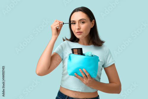 Young woman applying mascar...